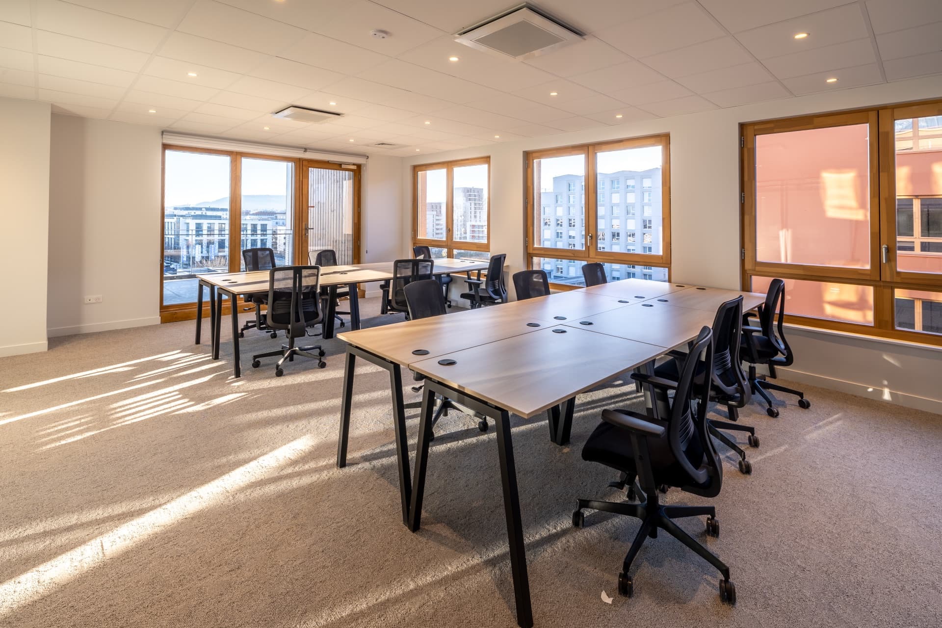 Un bureau partagé du PIC, grandes tables et fenêtres sur la ville